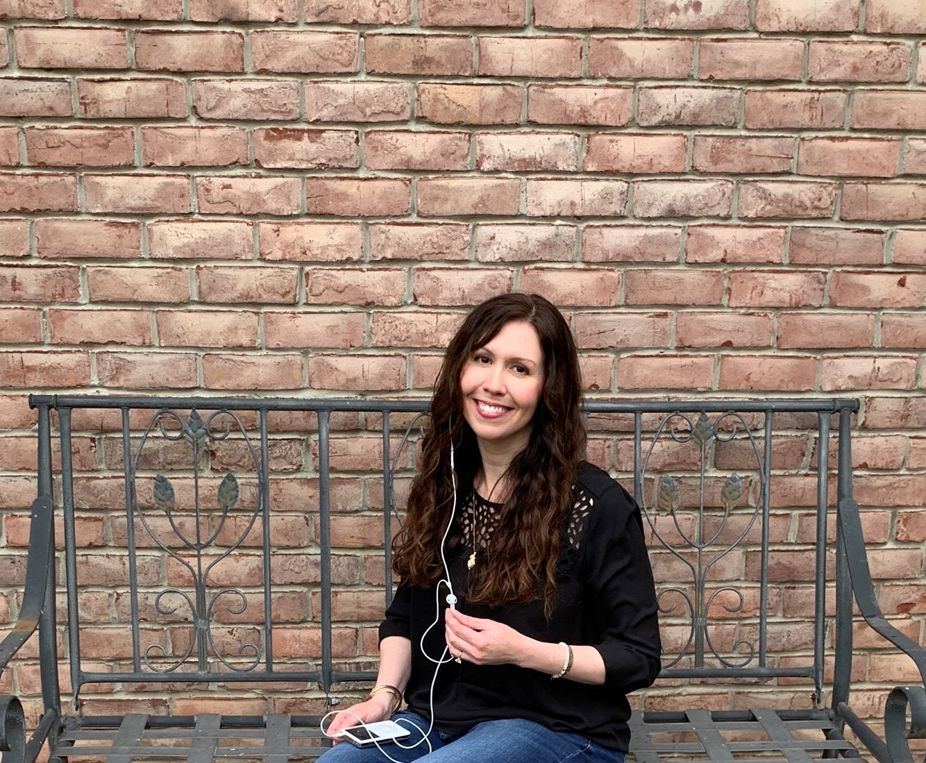 Kristy Boyd with ipod on weathered bench with metal leaf design Copyright 2020 Kristy Boyd