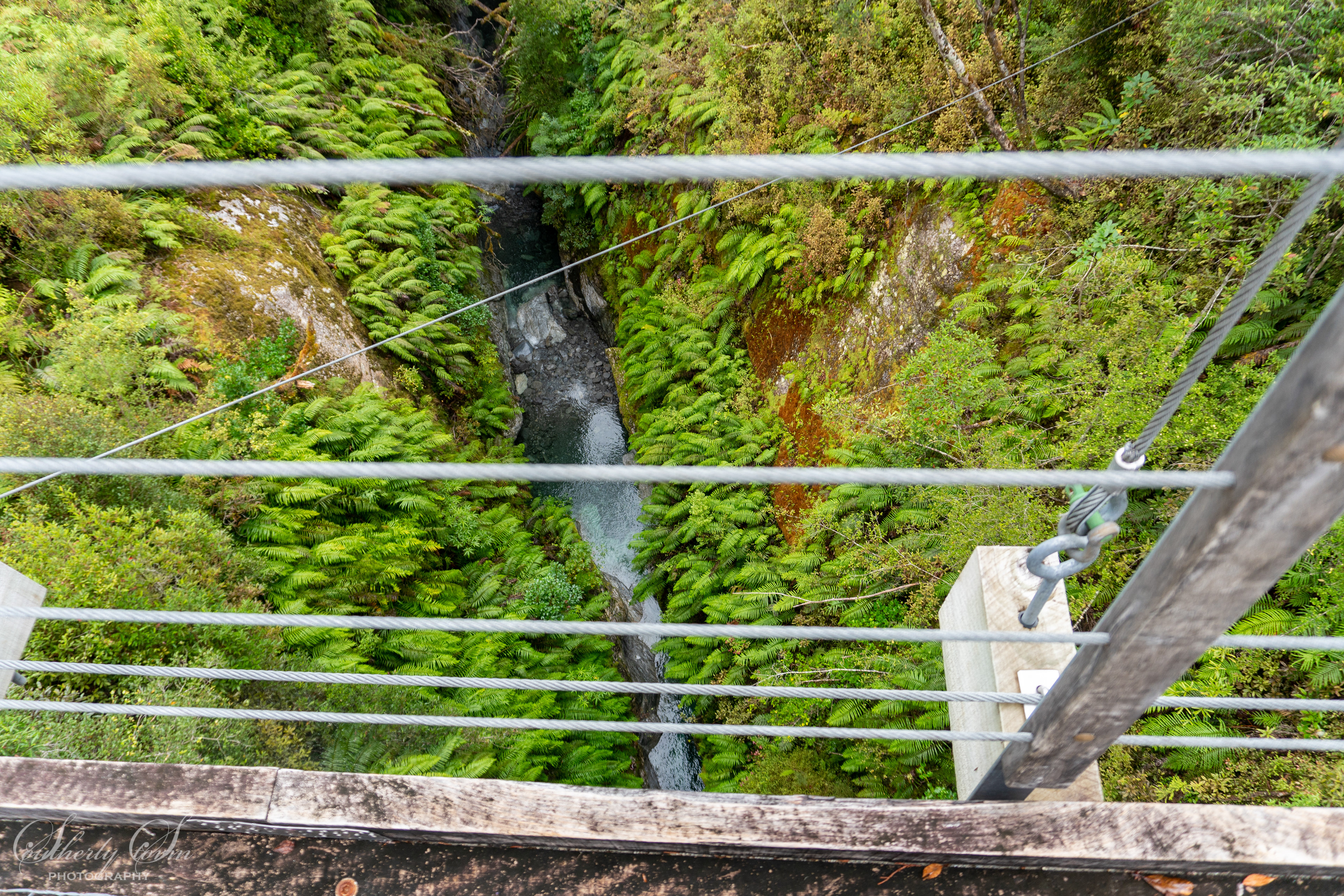 View down into a deep gulch off a bridge
