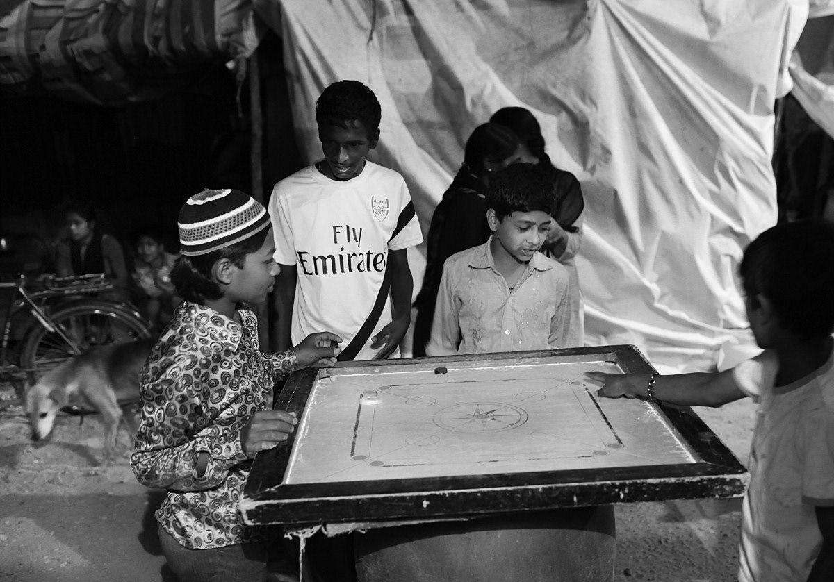 Children play carrom under a street light.2000 children were rendered homeless by the eviction, many of them as young as a few months. Atleast two pregnant women gave birth after becoming homeless as a result of the demolition.