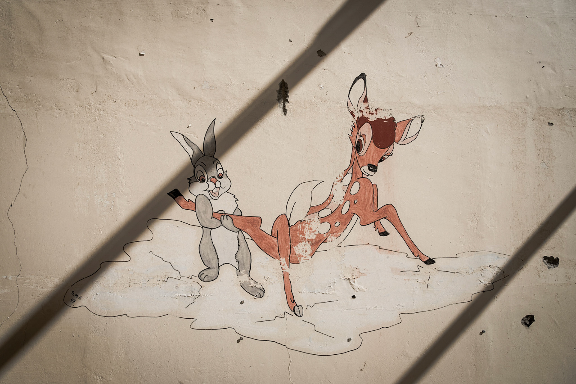Funny drawing of Bambi and a rabbit on a wall in the event hall at the abandoned Berengaria Village in Limassol, Cyprus