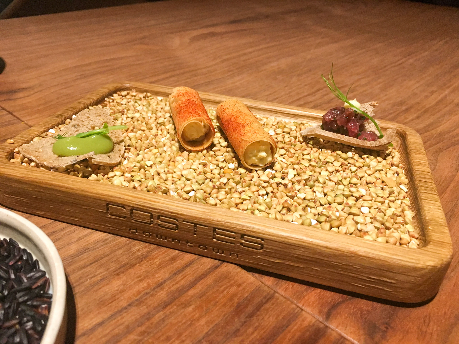 Amuse-Bouches served in a wooden tray filled with grain - Costes Downtown Restaurant - Budapest