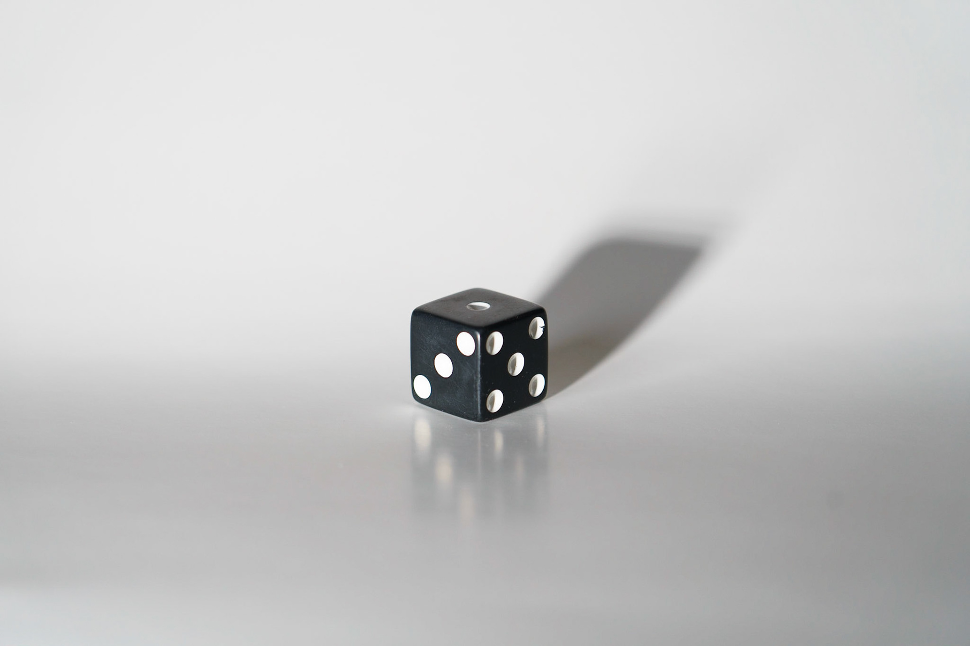 Concentrated Light: Dice on white paper, 20201107, MILLER, I used my light, with no filter or diffuser on it, making it a straight light onto the dice. The concentrated light ended up reflecting the dice onto the white because the light was so concentrated. I like the affect direct light gave this particular shot and the stark shadow behind it. Camera Settings: Sony A7II, ISO 200, 105mm, f4, 1/15s