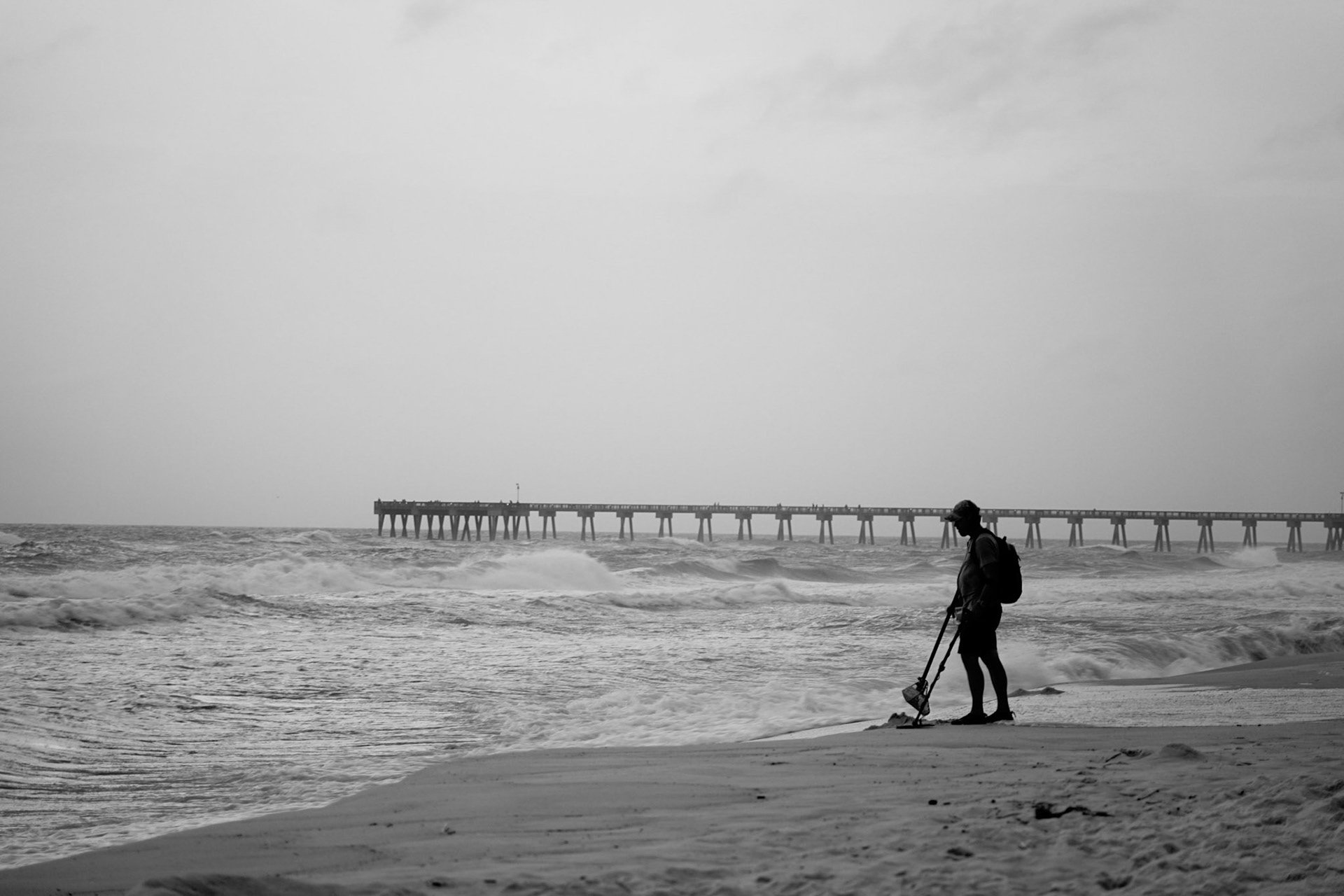 Isolation: Lone man on the beach looking for washed up treasures, 20201029, Panama City Beach, MILLER, I originally shot this on my camera in B&W, but chose to use this image as the contrast and the black and white work as tool to isolate the already alone man in the shot from the vast area around him. I chose to keep him darker, almost silhouette in order to draw your eye to the profile of him against the rest of the beach. Camera Settings: Sony A7 II, ISO 200, 105mm, f4, 1/50s