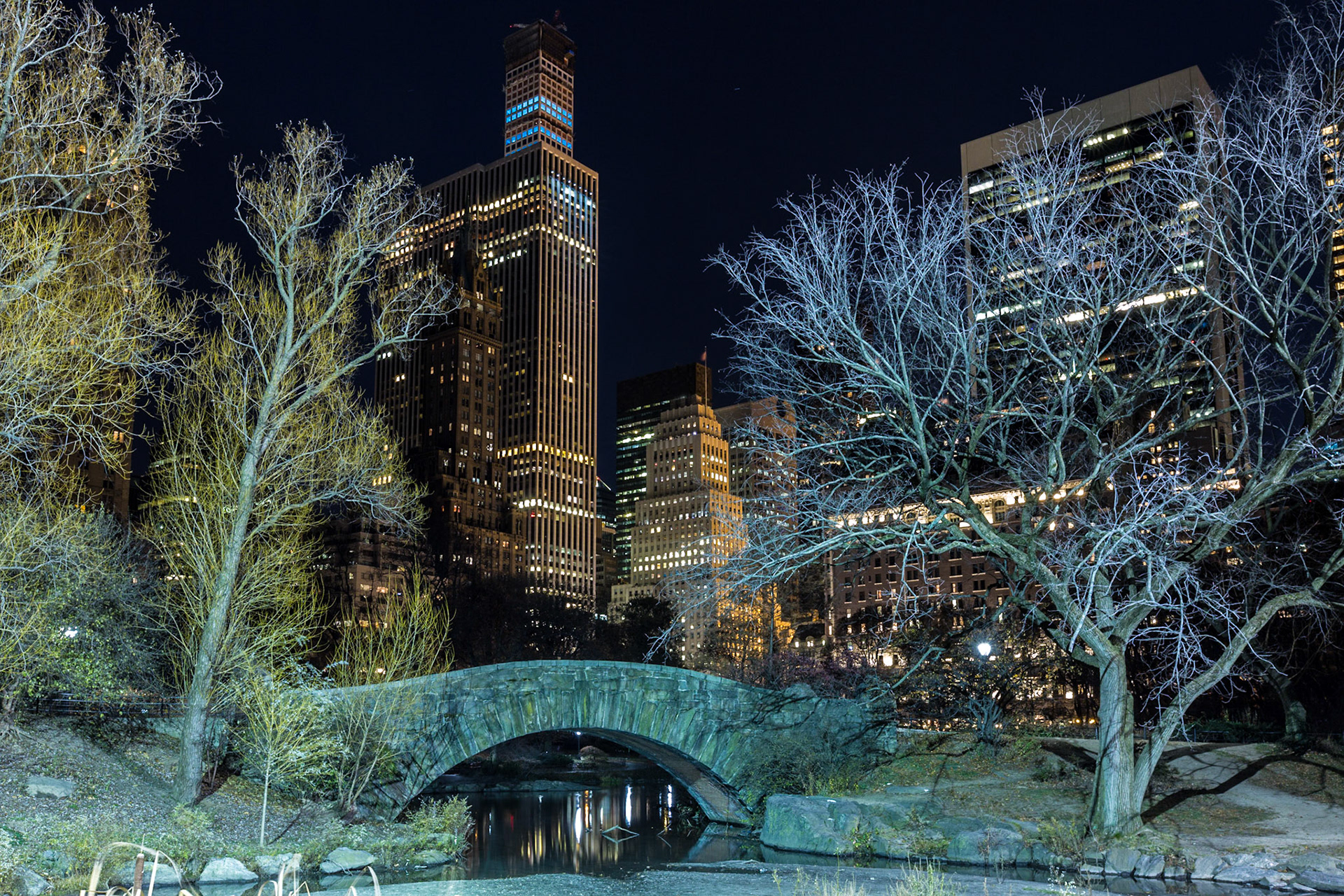 View of the Midtown Manhattan Skyline with the Gapstow Bridge in Central Park at night