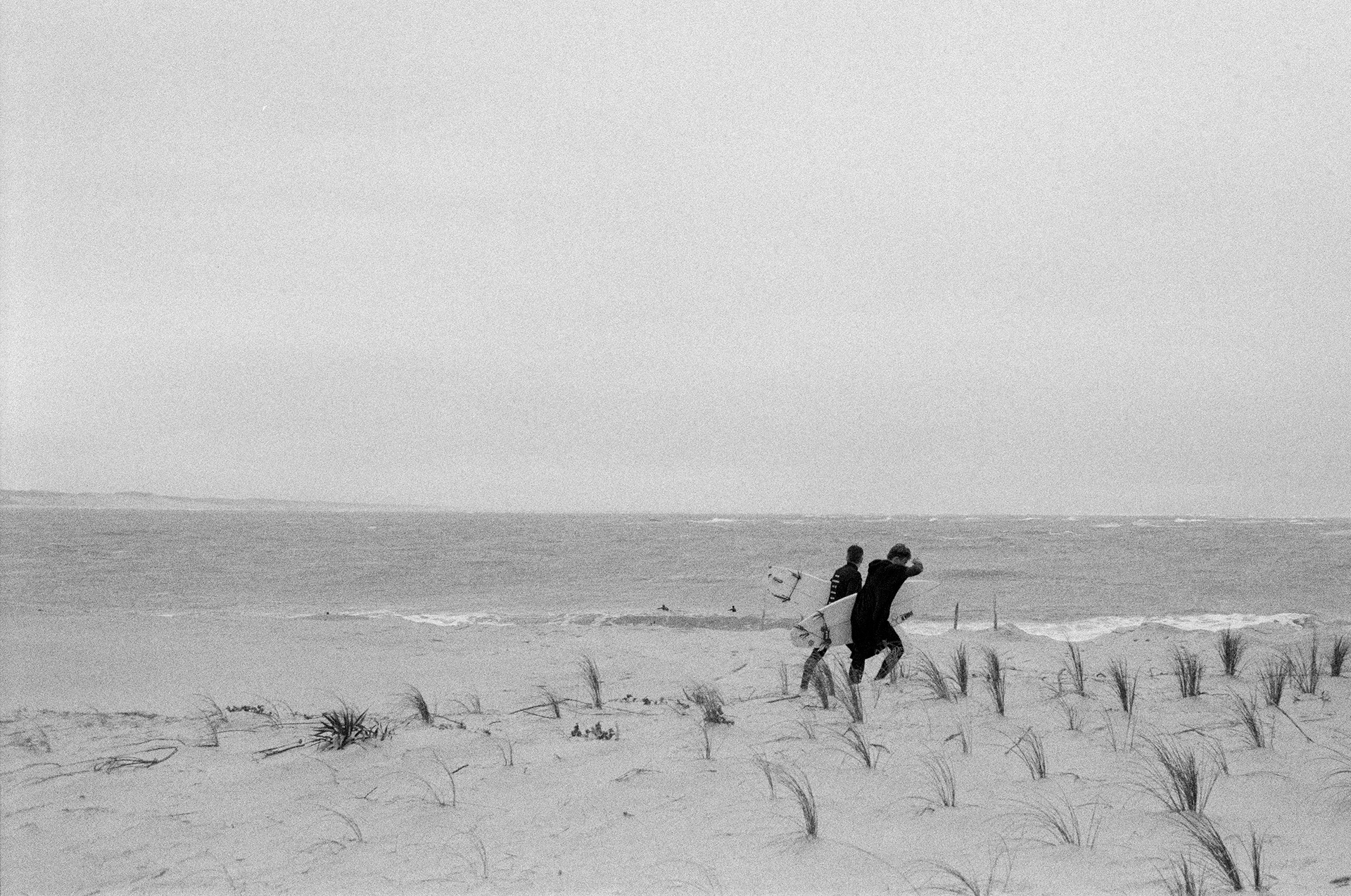 Surfers in Cap Ferret walking on the dunes