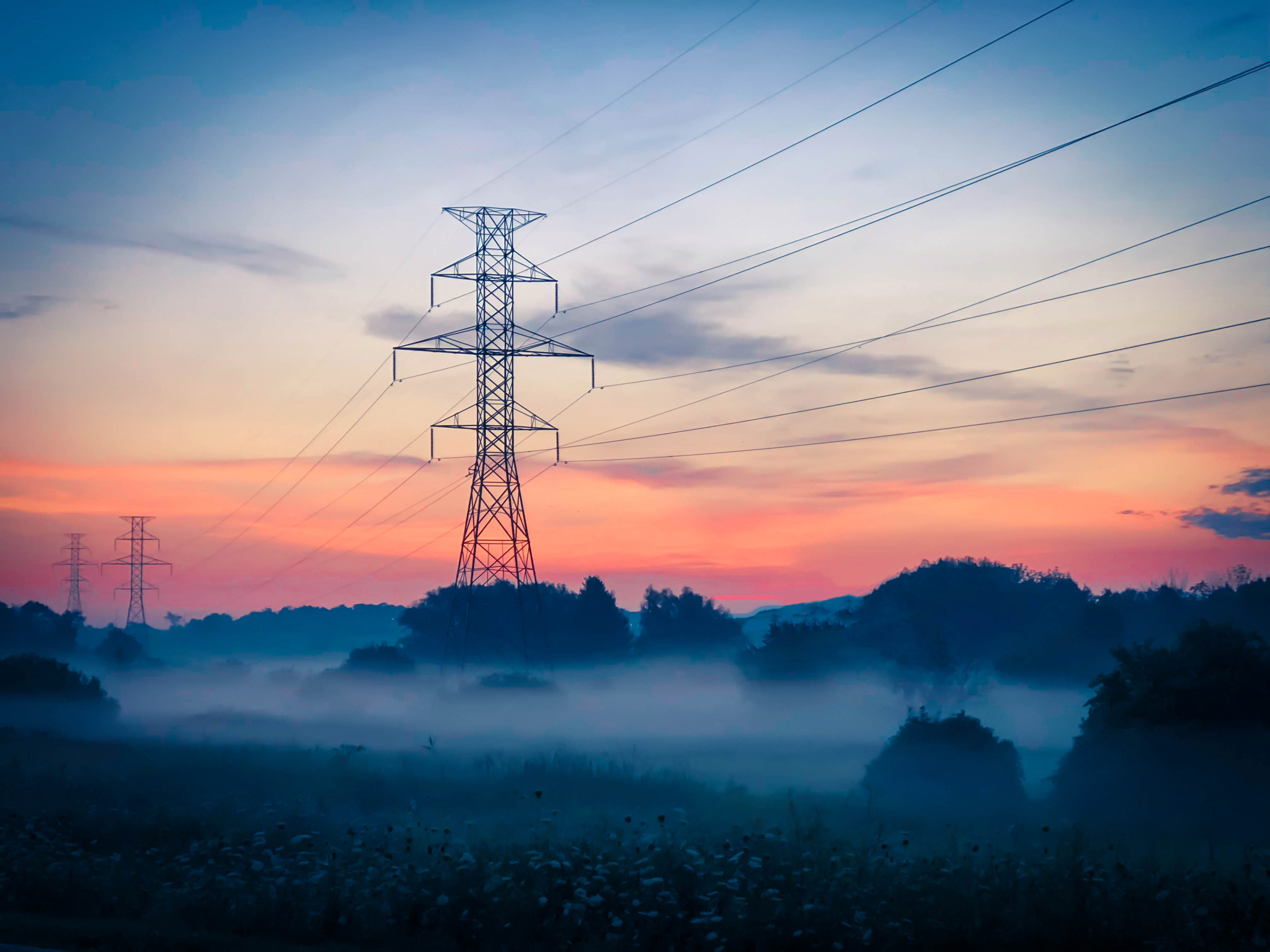 Misty fields and electrical towers/lines