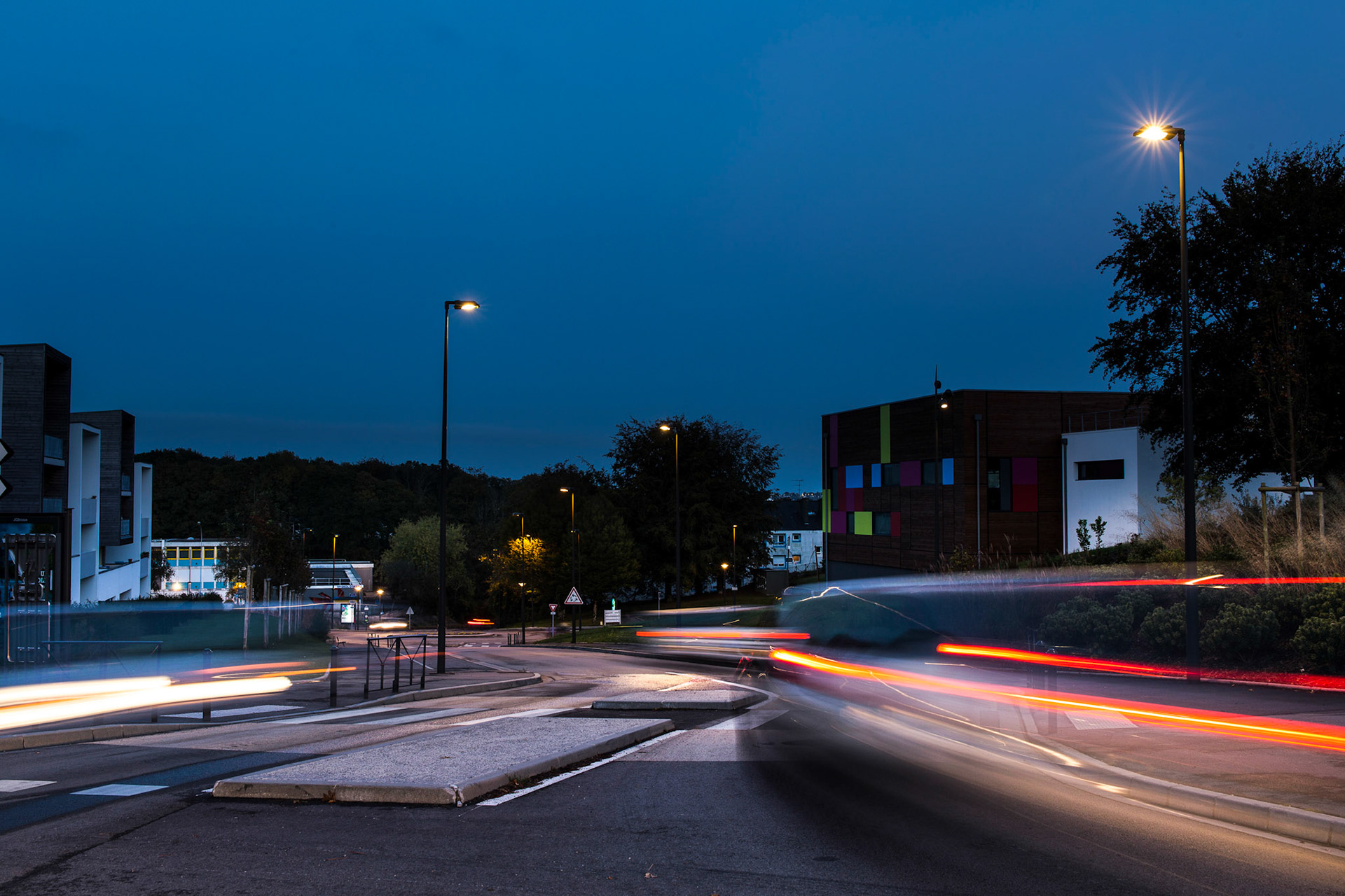 Dans le quartier de Penhars, à la tombée de la nuit, des voitures laissent des traînées sur des poses longues.