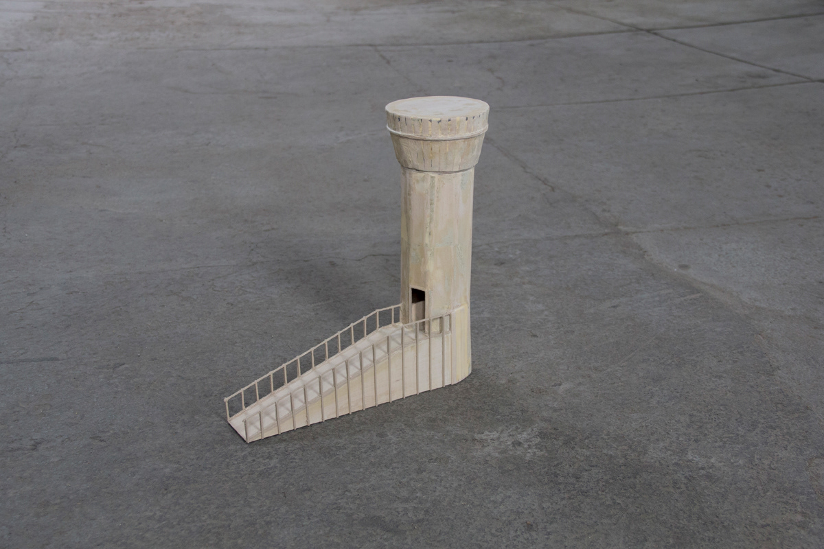 Balsa Wood model of a watchtower with an accessibility ramp sitting on the concrete floor.