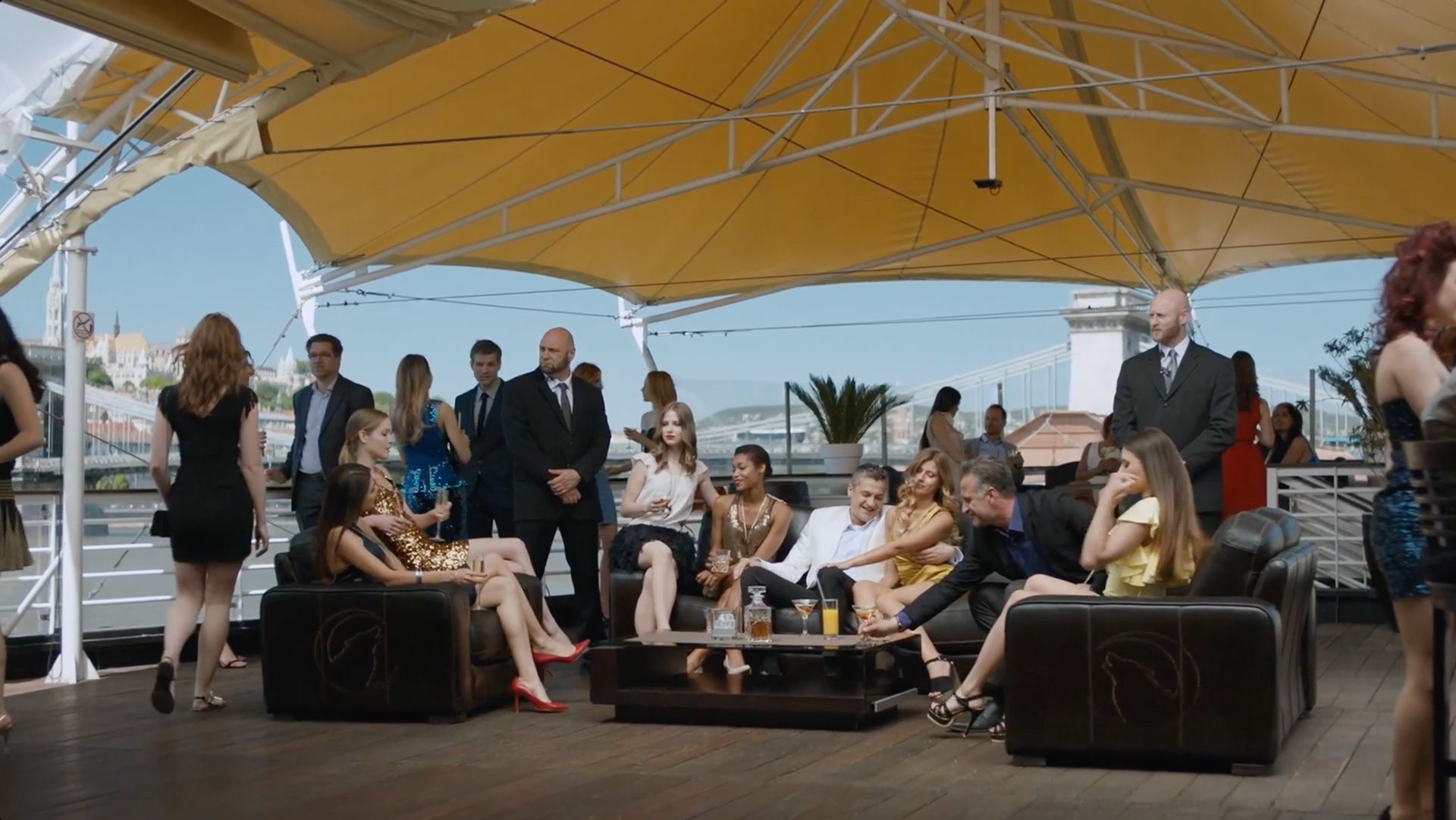 Young women, a mob boss, and body guards relaxing on a boat
