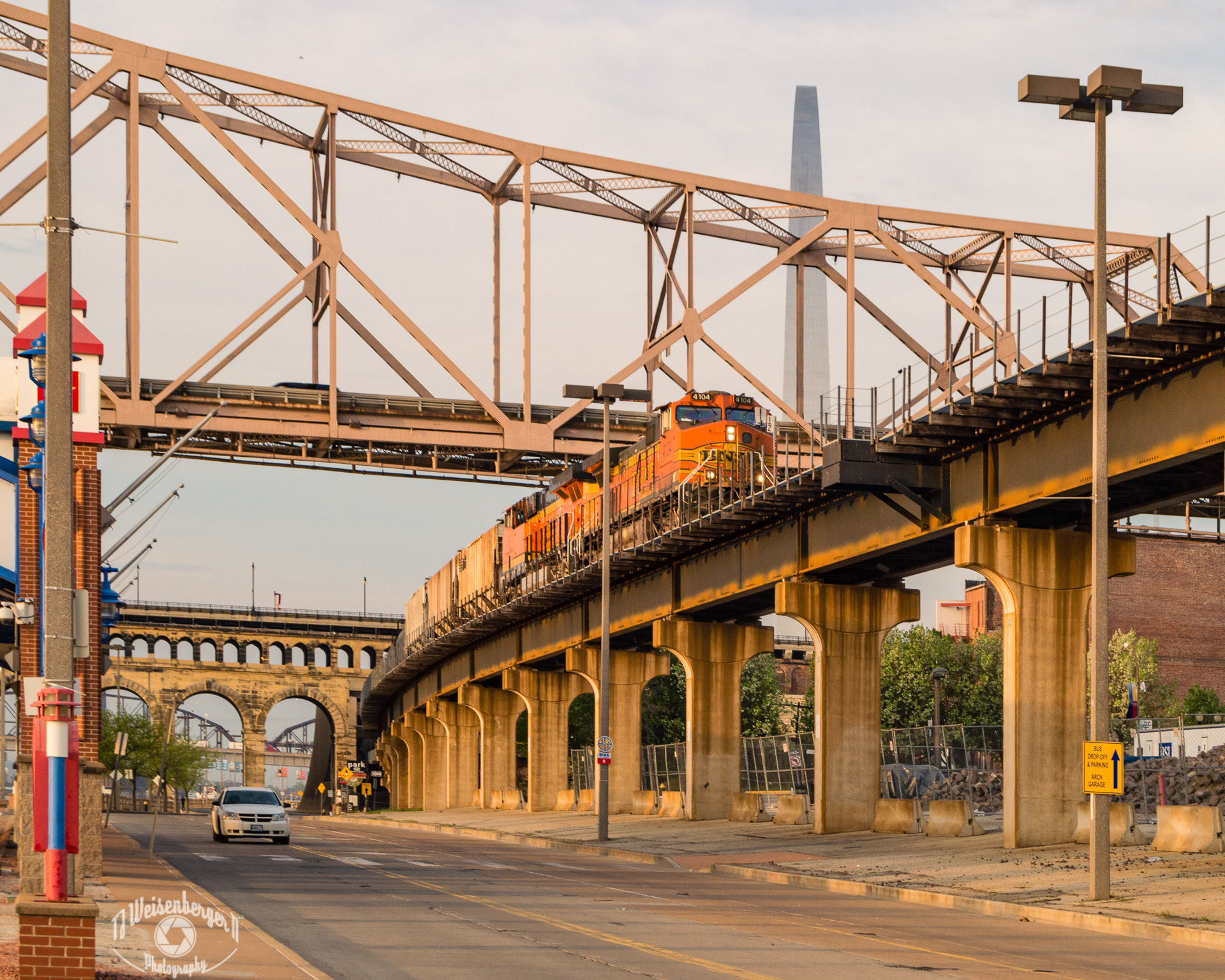 Morning Train, Staint Louis Riverfront Trail, Jefferson Expansion - St. Louis, Missouri; Arch; Bridges; Jefferson Expansion; Missouri; Morning; National Park; Photography; Saint Louis; St. Louis; Travel; Travel Destinations; United States; Waterfront; lines; street photography; train; urban;
