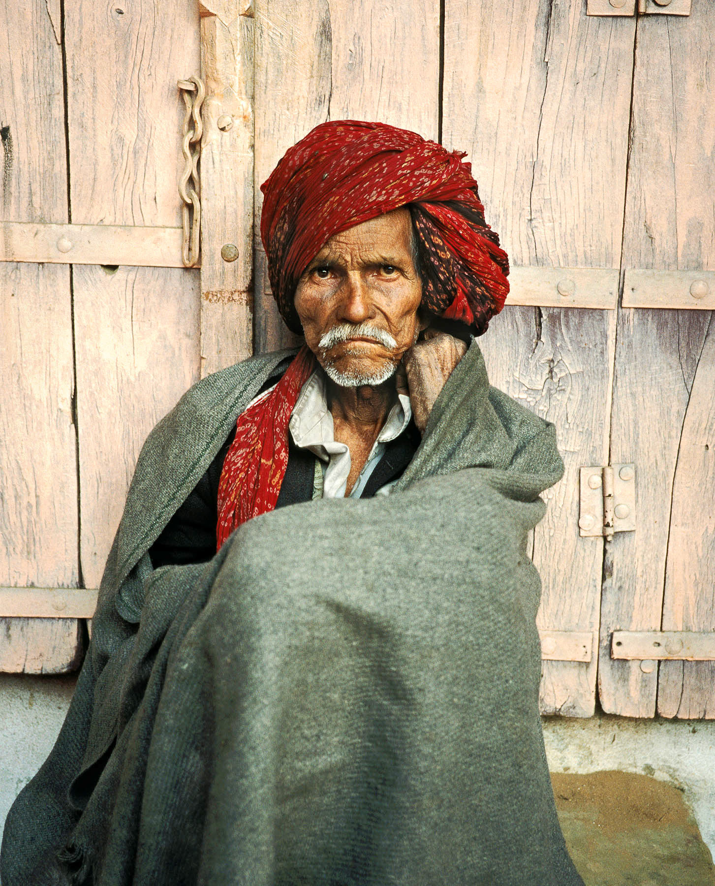 Rajasthani man sitting against the pink wall of the Old City, Jaipur, India 1994