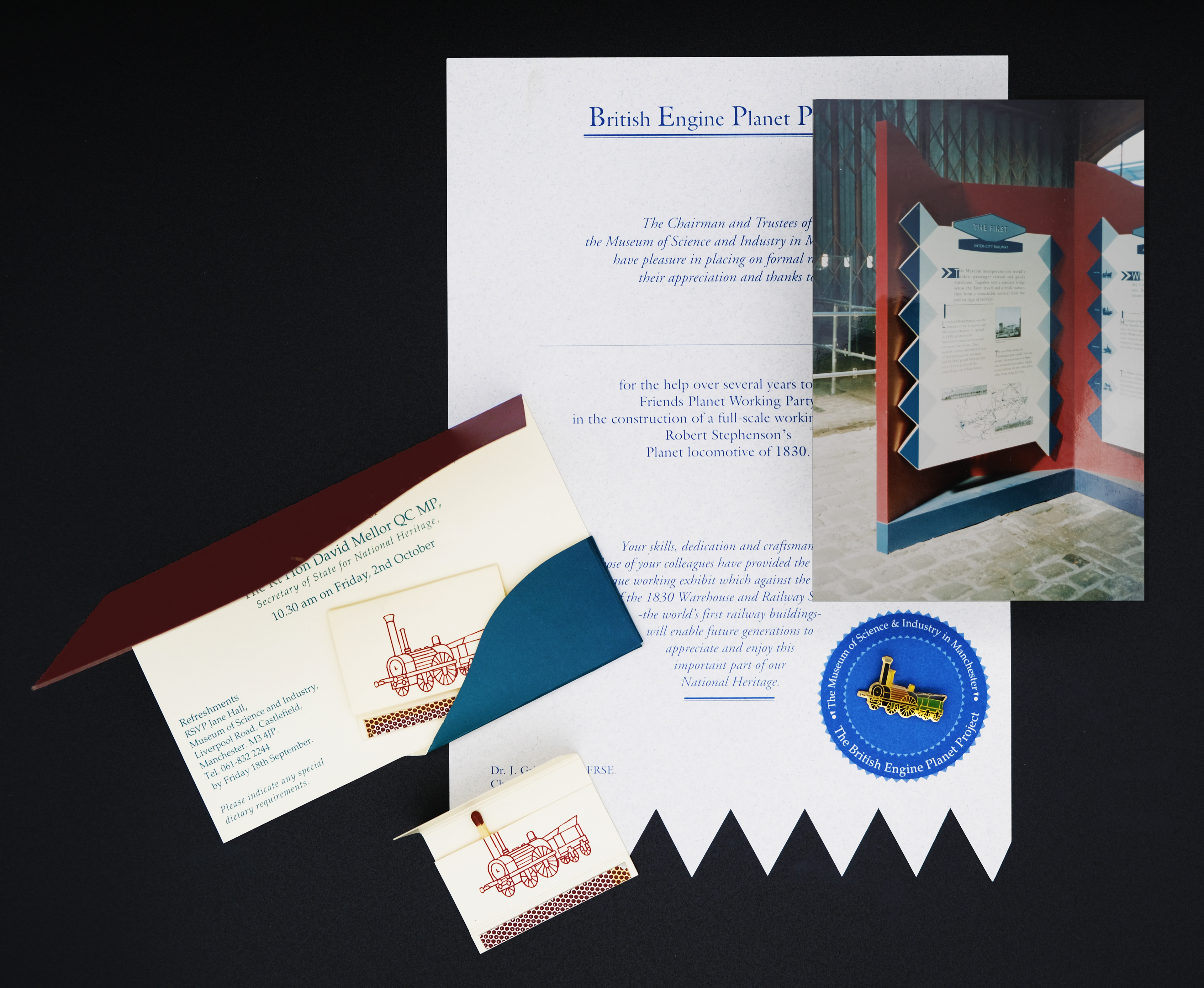 Planet steam train invitation showing illustration of the train as a book of matches with one match coming out of funnel. Certificate with planet train badge and a photograph of an exhibition panel.