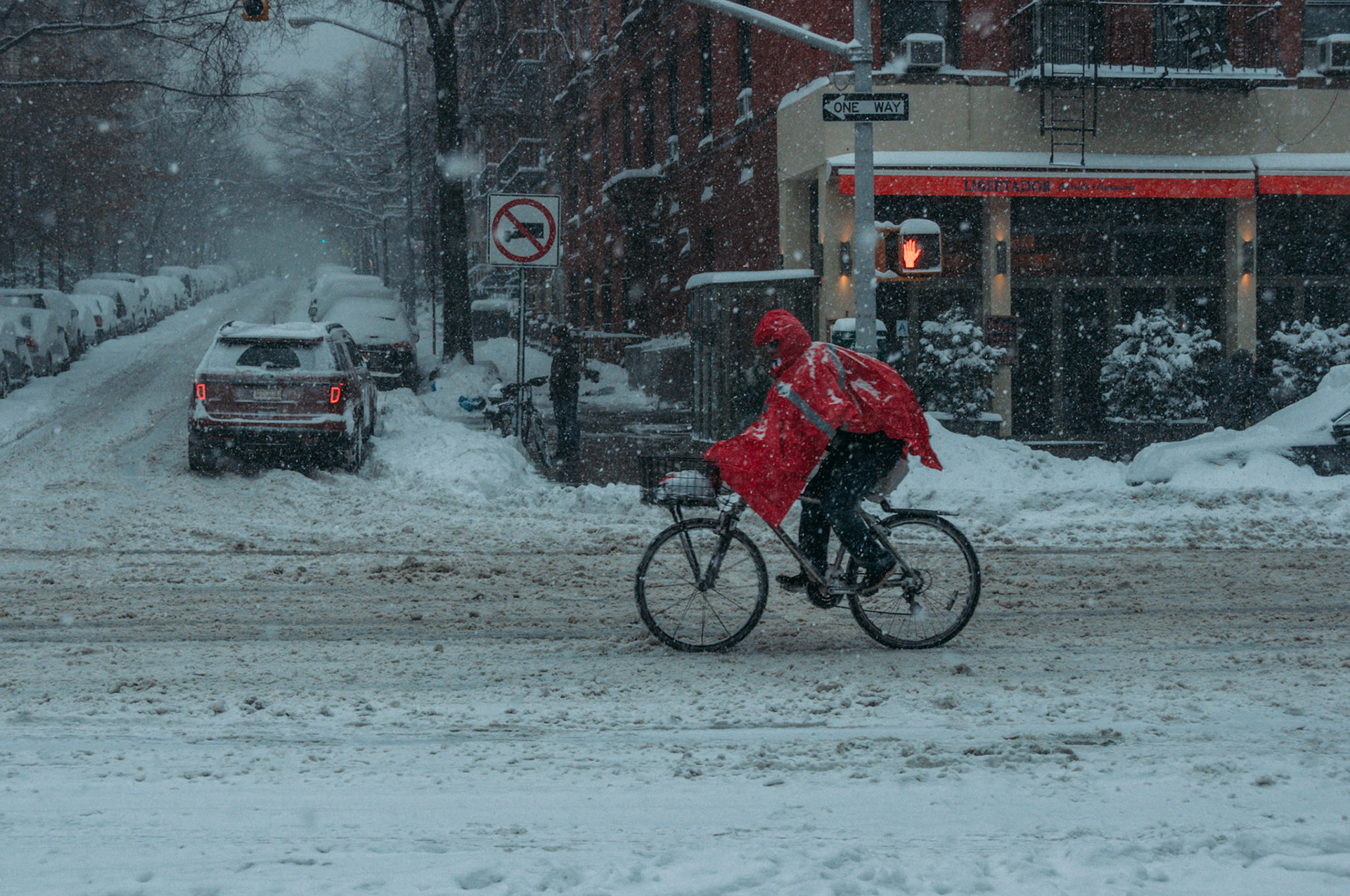 A delivery man on a bicycle braves the snow and wind of today's blizzard in New York City.