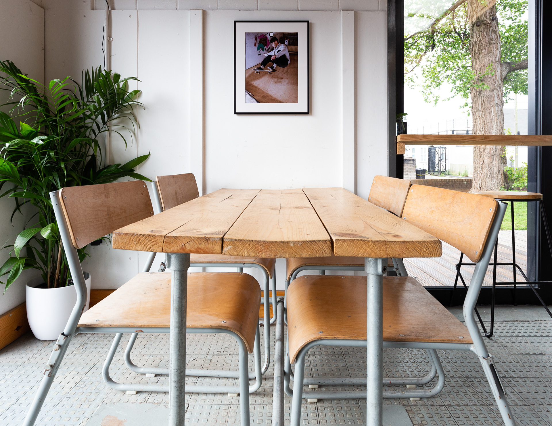 Interior photograph of vintage reclaimed wooden tables and chairs in Campus Skatepark bar and cafe area. Photographed by Jake Hitchcock, a Bristol based photographer