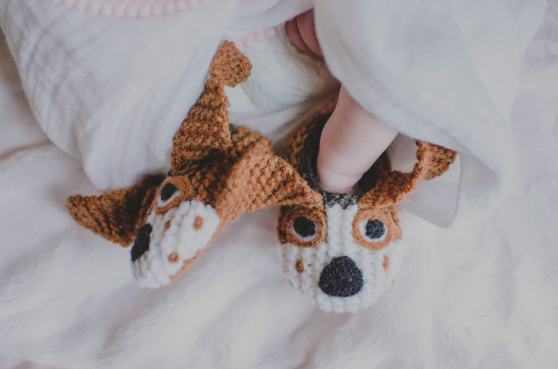 Picture of infant feet wearing dog slippers