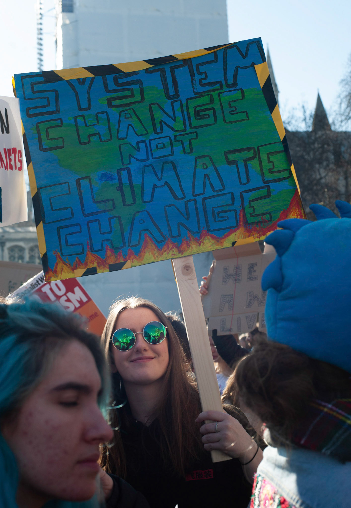 A smiling protester holds placard